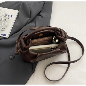 Intérieur spacieux d'un sac plissé vintage marron foncé contenant des objets quotidiens