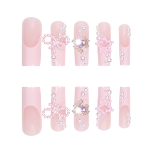 Pink press-on nails with pearl bows and heart rhinestones in a sweet French style