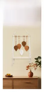 Détail d'une étagère murale en macramé bohème avec feuilles décoratives en coton