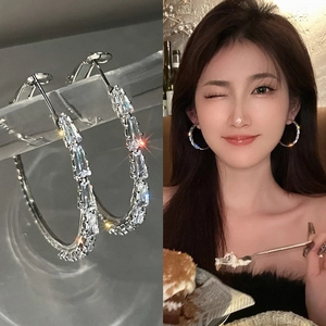Close-up and model view of silver hoop earrings with rectangular baguette crystals