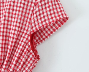 Detail shot of the red and white gingham puff sleeve dress with seersucker fabric texture