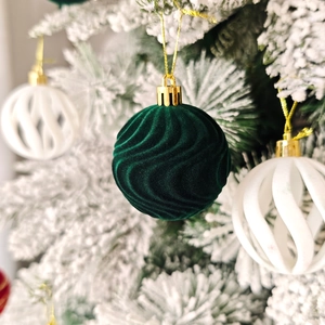 Détail de boule de Noël en velours vert foncé avec texture ondulée et cordon doré