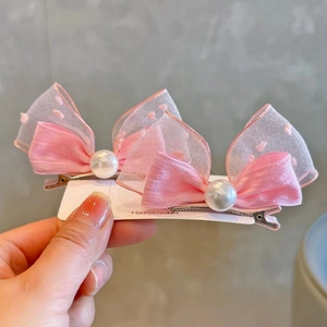 Detail of pink satin and mesh bow hair clips with a white pearl and silver duckbill clip
