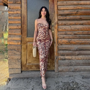 Sleeveless backless deep V leopard print bodycon maxi dress shown in a rustic street setting