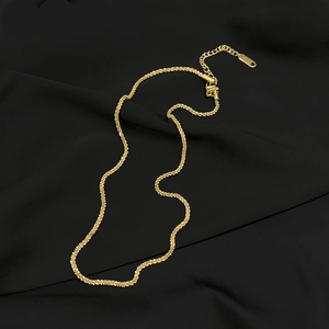 Detailed macro of a 18K gold-plated starburst chain necklace on black silk background