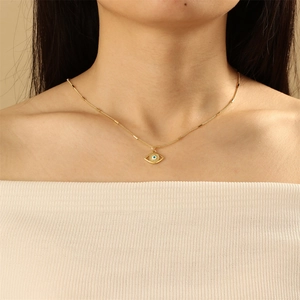 Minimalist gold plated necklace with evil eye pendant on model neck
