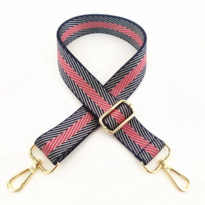 Adjustable woven strap with blue, red and grey geometric pattern and gold hardware