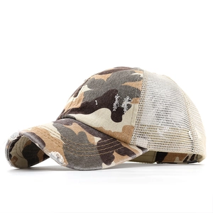 Detailed close-up of camouflage baseball cap with distressed brim and mesh backing