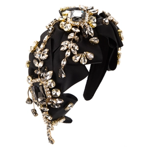 Detailed macro view of handcrafted rhinestones and vintage crystals on black velvet headband