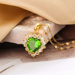Exquisite gold heart necklace with emerald green gemstone and halo diamonds on satin cloth