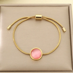 Détail du bracelet chaîne serpent dorée avec pierre rose et fermoir bolo réglable