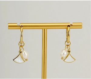 Detail of fan-shaped mother of pearl gold earrings with elegant freshwater pearls