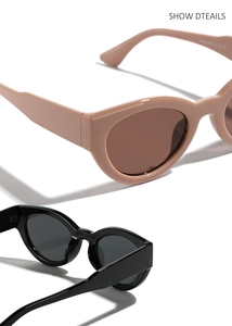 Close-up of retro oval sunglasses in black and beige with thick frames and tinted lenses