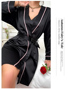 Détail d'un peignoir en satin noir avec liseré rose et ceinture à la taille élégante