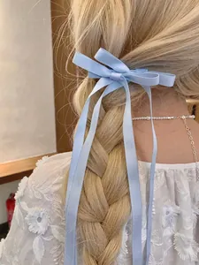 Nahaufnahme der hellblauen Satin-Schleife mit langen Bändern in einer Flechtfrisur