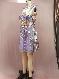 Détail de la broderie florale 3D et du tissu mesh sur une robe courte violette sans manches
