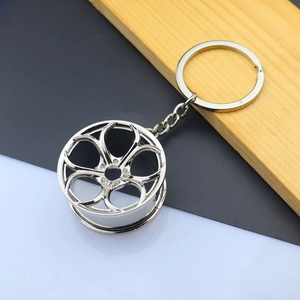 Macro shot of a bright silver zinc alloy car hub keychain with a five-spoke hollow design