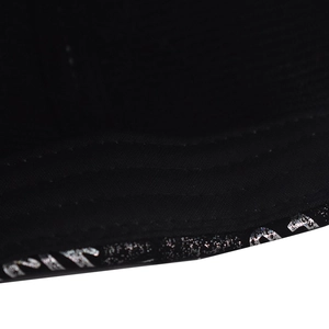 Macro detail of silver glitter print and stitching on a black baseball cap edge