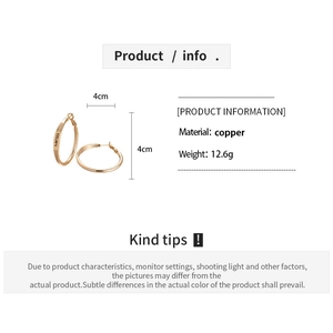 Detail view of 4cm gold hoop earrings made of copper with engraved letters and 12.6g weight
