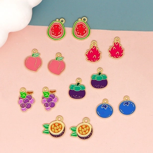 Flat lay of colorful fruit charms including watermelon and peach on a split pastel background