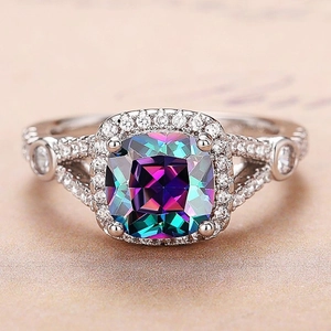 Close-up of square cushion-cut multicolor gem on silver band with pavé-set stones