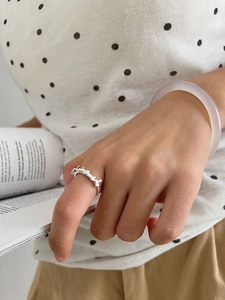 Detail of S925 sterling silver bow ring with adjustable open band on model hand