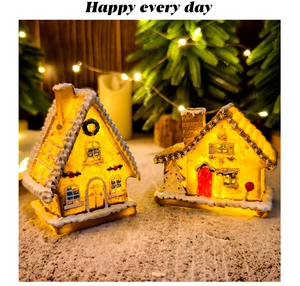 Macro shot of two LED resin gingerbread houses with warm glowing lights on snow surface