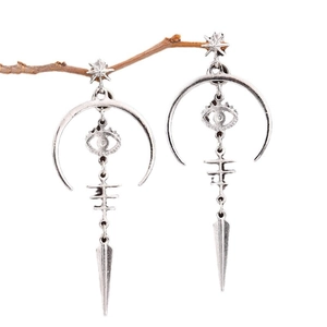 Gothic silver dangle earrings with devil eye and moon charms on a branch display