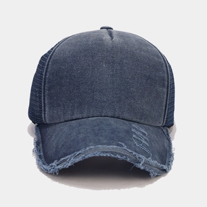 Dettaglio cappello trucker in denim slavato con bordi consumati e rete traspirante