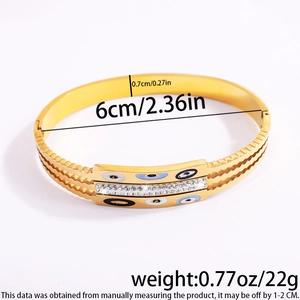 Detail view of gold stainless steel evil eye bangle with precise measurements and weight info