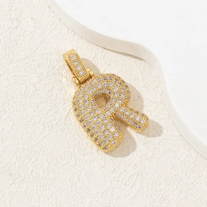 Macro shot of gold-plated letter R pendant with sparkling zircon micro-paving detail