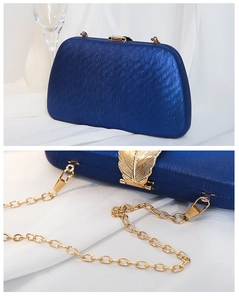 Dettaglio borsa da sera blu navy con chiusura a foglia dorata e tracolla in metallo