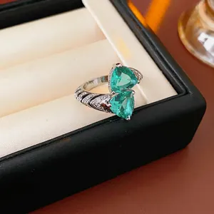 Vintage silver bypass ring with two triangle emerald stones and sparkling zircon pavé