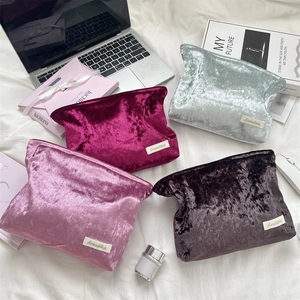 Flat lay of velvet makeup bags in four colors with embossed texture and Sorakka labels