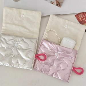 Close-up of quilted heart pouches in silver and pink with interior canvas and button detail