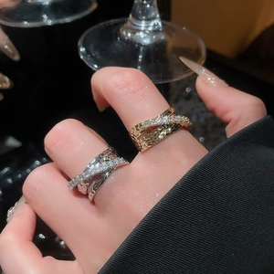 Macro shot of gold and silver layered crisscross rings with sparkling zircon inlay