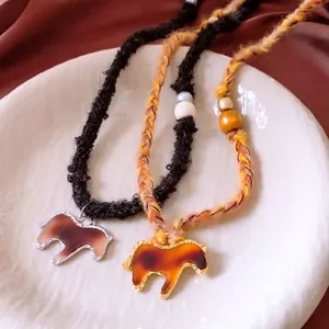 Knitted rope necklace with horse pendant featuring tortoiseshell pattern and wood beads