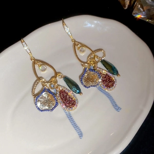Close-up of vintage drop earrings with sparkling crystals and long chain tassels
