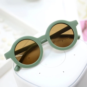 Close-up of kids round frame sunglasses with UV400 and CE protection stickers on lens