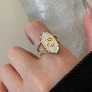 Detail of 18k gold plated stainless steel teardrop bracelet with sunburst mother of pearl