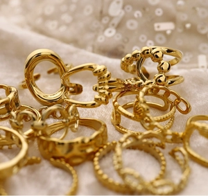 Close-up of assorted 18K gold plated stainless steel rings on soft white plush fabric