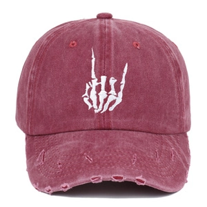 Close-up of vintage burgundy washed cotton baseball cap with rock gesture embroidery