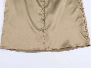 Vue détaillée de la chemise en soie champagne avec boutons ronds et coutures de l'ourlet