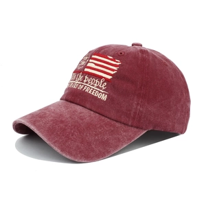 Detail of vintage washed red baseball cap featuring detailed American flag embroidery