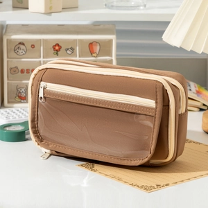 Brown canvas multi-layer pencil case with transparent PVC window on a cozy desk setup