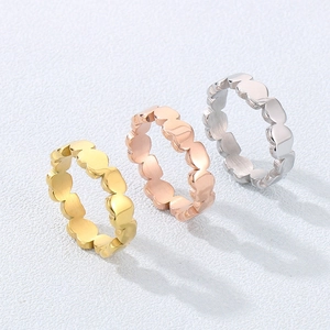 Detailed macro view of heart-shaped linked rings in gold, rose gold and silver finishes