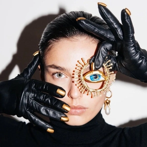 Kreative goldene Evil Eye Brosche mit blauem Auge und Diamanten auf schwarzem Leder