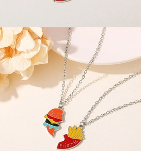 Detail of Best Friends necklaces with rainbow burger and fries shaped metal pendants