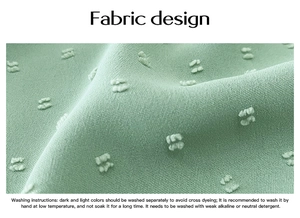 Detailed macro shot of green fabric featuring pom-pom textures and care instruction label