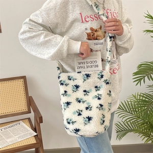 Detailed close-up of a soft plush tote bag with a blue floral pattern in a lifestyle setting